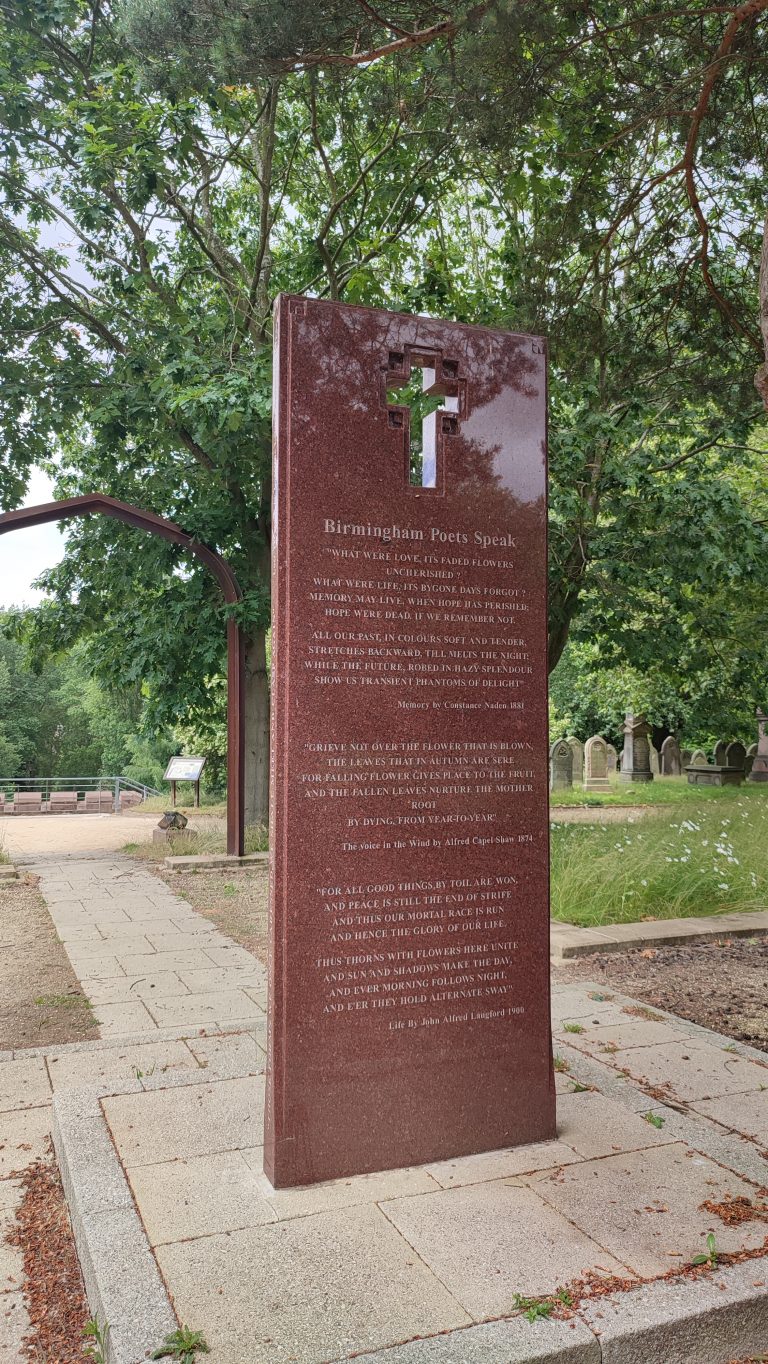 A marble headstone with a poem and a cross